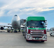 飛行機の横で待機するタツミトランスポートのトレーラー