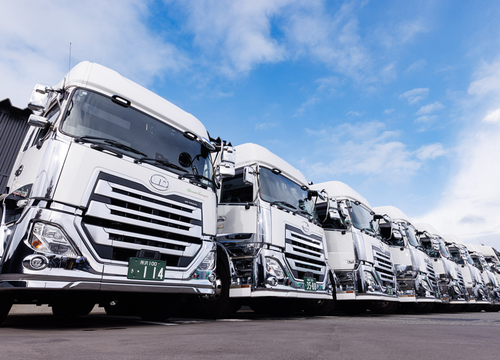 ロジティクスセンターの前に並ぶタツミトランスポートの白のトラクターヘッド